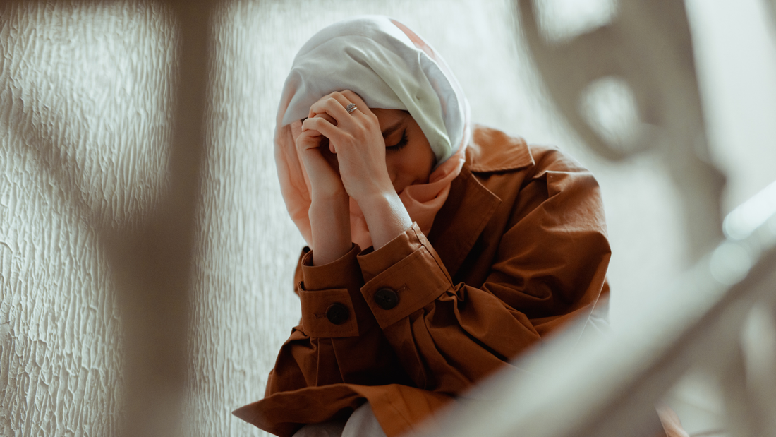 person reflecting quietly, hands raised in dua